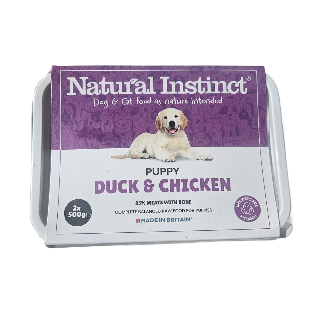 Package of Natural Instinct puppy food with duck and chicken on a white background